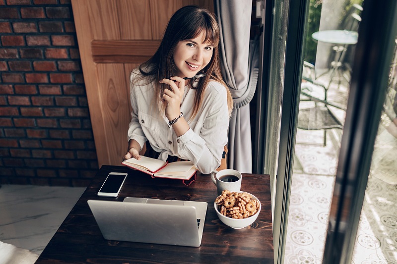zadowolona kobieta z bycia freelancerem siedząca w domu z laptopem